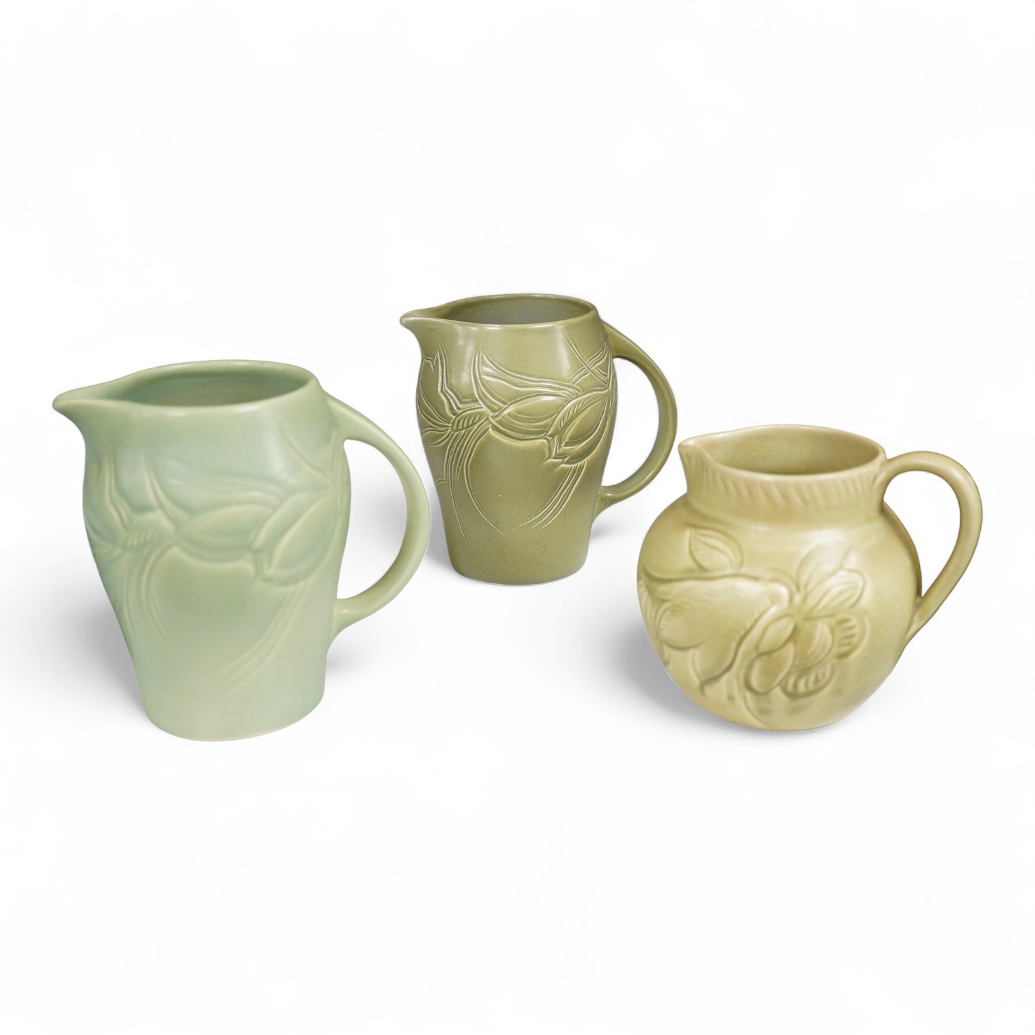 Three Susie Cooper green floral incised jugs, signed to the bases, tallest 16cm high